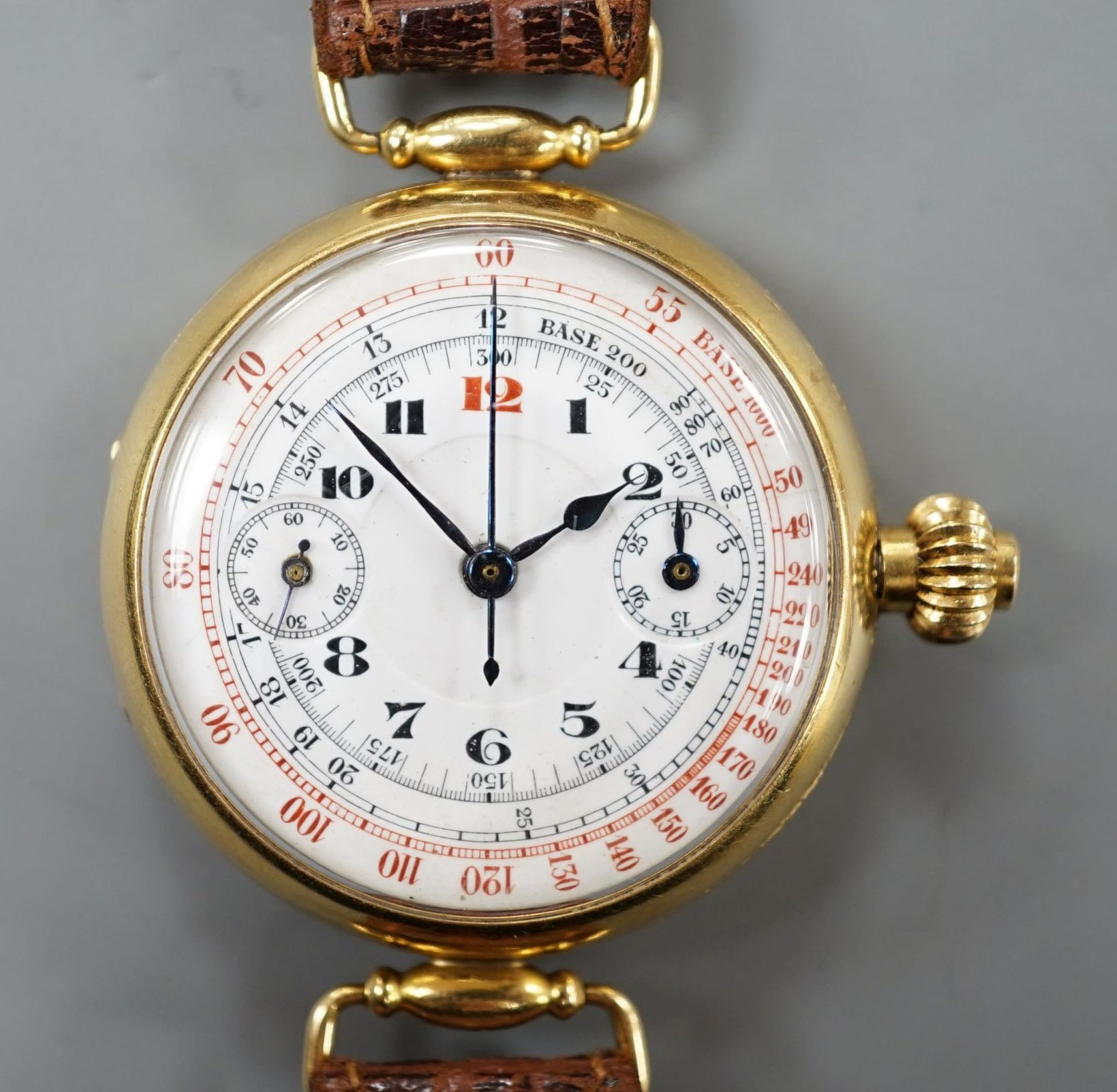 A gentleman's early 20th century 18k single button chronograph manual wind wrist watch, with enamelled Arabic dial and two subsidiary dials, with swivel lugs, on a later strap